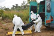 WORK OF MERCY. Health workers at a burial in northern Sierra Leone. 