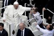 Pope Francis caresses a child as he makes a tour of St. Peter's Square at the end of a Mass for the the Holy Year of Mercy, at the Vatican, Sunday, April 3, 2016. (AP Photo/Alessandra Tarantino)