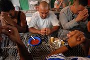 Migrants pray before breakfast at a dining facility in Nogales, Mexico, that is supported by the Jesuit-run Kino Border Initiative. (CNS photo/David Maung)