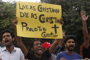 Member of Christian community holds placard during rally to condemn suicide attack on church in Pakistan.