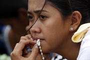 Woman with rosary waits for evacuation flight from tyhoon-battered city in Philippines (CNS photo/Edgar Su, Reuters)
