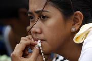 Woman with rosary waits for evacuation flight from tyhoon-battered city in Philippines (CNS photo/Edgar Su, Reuters)
