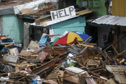 Resident places laundry on umbrella to dry in typhoon-battered city of Tacloban (CNS photo/Romeo Ranoco, Reuters)