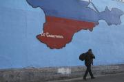 A man passes a mural showing a map of Crimea in Russian national colors on a street in Moscow. (CNS photo/Artur Bai nozarov, Reuters) 