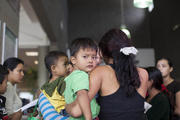 Migrants, consisting of mostly women and children, who disembarked from a U.S. Immigration and Customs Enforcement bus, wait for a Greyhound official to process their tickets to their next destination at a bus station in Phoenix May 29. (CNS photo/Samantha Sais, Reuters) 