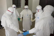 Health workers wearing protective equipment pray at start of shift before entering Ebola treatment center in Liberia. (CNS photo/Christopher Black, WHO, Handout via Reuters) 