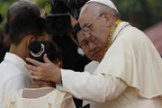 Pope Francis comforts former street child who spoke during meeting with young people at university in Manila.