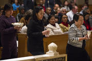 Human trafficking survivors carry offertory gifts to altar at during Mass at national shrine.