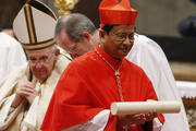 New Cardinal Charles Bo of Yangon, Myanmar, carries his scroll after receiving his red biretta from Pope Francis during a consistory at which the pope created 20 new cardinals in St. Peter's Basilica at the Vatican Feb. 14. (CNS photo/Paul Haring)