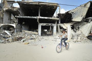 RIDE AMONG THE RUINS: A boy rides his bike amid the ruins of Khan Younis, Gaza Strip, June 9. Houses in the area were destroyed during the 2014 war between Israel and the Hamas government of Gaza. (CNS photo/Paul Jeffrey) 