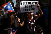 Woman protests near the office of a hedge fund manager in New York Aug. 13 over the financial crisis gripping Puerto Rico. A Senate committee held hearings Oct. 22 to discuss solutions to the crisis. (CNS photo/Justin Lane, EPA) 