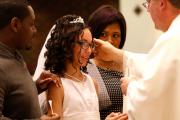 Dejia Solomon, 12, is anointed with chrism by Father Christopher Nowak during Mass April 2 at St. John of God Church in Central Islip, N.Y.