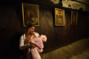 A pilgrim from India holds her baby in front of a painting of the Mary and the Christ Child in the grotto of the Church of Nativity in Bethlehem. (CNS photo/Debbie Hill)