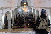 An Iraqi policeman stands guard as worshippers pray during Christmas Eve Mass in 2016 at al-Tahira al-Kubra church in Mosul. (CNS photo/Mohammed Badra, EPA)