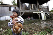 A boy holds a family chicken outside his home in Steele, Ala., in this 2013 file photo. (CNS photo/Karen Callaway, Catholic New World) 