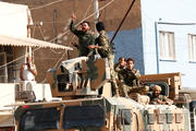 Members of Syrian National Army, known as the Free Syrian Army, react as they drive on top of an armored vehicle Oct. 11, 2019, in the Turkish border town of Ceylanpinar. Dozens of advocacy organizations participating in the International Religious Freedom Roundtable called on U.S. President Donald Trump "not to abandon Christians, Yazidis and Kurds" in the Syrian border region that Turkey is bombing. (CNS photo/Murad Sezer, Reuters)