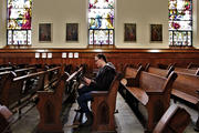 A woman reads a prayer book in the sanctuary of St. Mary Church in Appleton, Wis., on March 18,. Bishop David L. Ricken of Green Bay announced on March 17 that all public Masses in the diocese are suspended for the next four to eight weeks due to the coronavirus pandemic. (CNS photo/Brad Birkholz)