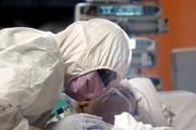 A medical worker in a protective suit treats a coronavirus patient in an intensive care unit at the Casalpalocco hospital in Rome March 24, 2020. (CNS photo/Guglielmo Mangiapane, Reuters)