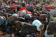 Migrant workers crowd outside a bus station in Ghaziabad, India, March 28, 2020, as they wait to board buses to return to their villages during a 21-day nationwide lockdown to limit the spread of COVID-19. (CNS photo/Anushree Fadnavis, Reuters)