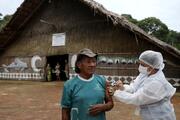 An Indigenous man receives the AstraZeneca/Oxford COVID-19 vaccine from a municipal health worker in the Sustainable Development Reserve of Tupe in Manaus, Brazil, Feb. 9, 2021. (CNS photo/Bruno Kelly, Reuters)