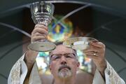 A priest raises the chalice and Communion host in this illustration. (CNS photo/Bob Roller)