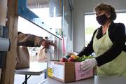 Maryann Arceo, a volunteer at St. Anthony's Padua Dining Room in Menlo Park, Calif., listens to a man as he receives a box of free groceries at St. Anthony's Catholic Church Nov. 18, 2021. The program provides about 300 meals every day, except Sunday, as well as groceries to anyone in need. (CNS photo/David Maung)