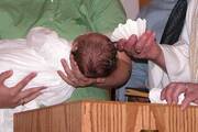 A baby is baptized in this 2007 file photo. Father Andres Arango, pastor of St. Gregory Parish in Phoenix, submitted his resignation letter to Phoenix Bishop Thomas J. Olmsted Feb. 1, 2022, for performing invalid baptisms throughout his ministry by regularly using an incorrect formula. (CNS photo/Lisa Schulte, Catholic Voice)