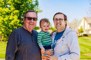 The author, his father and his infant son outdoors in front of a tree.