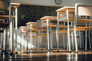 desks in a classroom without students in them, blackboard in the back