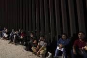 Migrants wait to be processed by Border Patrol after crossing into the United States near Yuma, Ariz., on Aug. 23. (AP Photo/Gregory Bull)