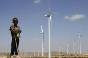 A boy stands before wind turbines at the Ashegoda Wind Farm, near Mekele in Ethiopia's Tigray region. Congolese Cardinal Fridolin Ambongo Besungu said the climate crisis is holding back African development. (CNS photo/Kumerra Gemechu, Reuters)