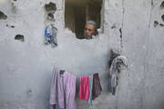 A Palestinian looks out from a hole in the wall of his house, damaged by airstrikes, in Rafah, southern Gaza Strip, on Oct. 18, 2023. (AP Photo/Hatem Ali)