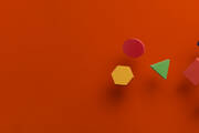 Image of multicolored shapes against a red background 