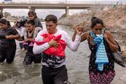 Yusniel, a migrant from Cuba, holds his 10-day-old son, Yireht, and wife, Yanara, along the banks of the Rio Grande after wading into the United States from Mexico at Eagle Pass, Texas, on Oct. 6, 2023 (OSV News photo/Adrees Latif, Reuters)