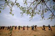 Sudanese refugees who have fled the violence in their country walk in line in the desert in Koufroun, Chad, to receive food rations in May 2023. (OSV News photo/Zohra Bensemra, Reuters)