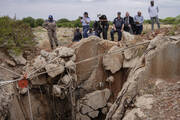 Authorities in Stilfontein, South Africa, survey the entrance to an abandoned mine shaft, part of a police effort to bring miners below to the surface on Nov. 15. Photo by Ihsaan Haffejee/GroundUp (CC BY-ND 4.0).