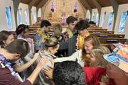 Students and adult leaders pray over English teacher Jen Morris on a Kairos retreat at Brebeuf Jesuit Preparatory School in Indianapolis (Amanda Murphy)