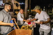 Two male "Lights On" volunteers distribute food to recently released prison inmates. (IStock/:pandapix)