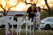 Meredith Cooper, of San Antonio, Tex., and her 8-year-old daughter, Heather, visit a memorial of 26 metal crosses near First Baptist Church in Sutherland Springs, Tex., on Nov. 6. (Jay Janner/Austin American-Statesman via AP)