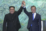 In this image made from video provided by Korea Broadcasting System (KBS), North Korean leader Kim Jong Un, left, and South Korean President Moon Jae-in raise their hands after signing on a joint statement at the border village of Panmunjom in the Demilitarized Zone Friday, April 27, 2018. (Korea Broadcasting System via AP)