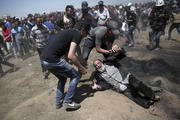 An elderly Palestinian man falls on the ground after being shot by Israeli troops during a deadly protest at the Gaza Strip's border with Israel on May 14. Thousands of Palestinians are protesting near Gaza's border with Israel, as Israel celebrates the inauguration of a new U.S. Embassy in contested Jerusalem. (AP Photo/Khalil Hamra)