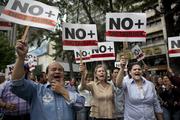 “No more dictatorship” is the message of this walkout against President Nicolas Maduro in Caracas on Jan. 30. Doctors in scrubs, businessmen in suits and construction workers in jeans gathered to demand that Maduro step down in a demonstration organized by the nation's reinvigorated opposition. (AP Photo/Ariana Cubillos)