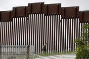 A border patrol agent walks along a wall separating Tijuana, Mexico, from San Diego on March 18. (AP Photo/Gregory Bull)