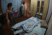 Relatives stand next to the body of Raimundo Costa do Nascimento, 86, at his home in Sao Jorge, Manaus, Brazil, on April 30. According to the family, Costa do Nascimento died of pneumonia and had to wait 10 hours for funerary services to come pick up his body. (AP Photo/Edmar Barros)