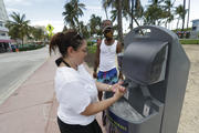 Maria Gomez, foreground, washes her hands at a public sink in Miami Beach, Fla., on June 22. (AP Photo/Wilfredo Lee)