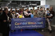 Refugees sponsored by the Vatican and the Sant’Egidio Community hold a banner supporting “Human Corridors” upon their arrival at Fiumicino airport on Dec. 4. (AP Photo/Alessandra Tarantino)