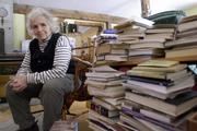 Grace Paley sits beside a pile of books in her home in Thetford Hill, Vt., April 9, 2003 (AP Photo/Toby Talbot).