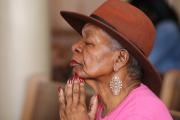 An elderly woman prays during Mass Nov. 13 at St. Peter Claver Church in Baltimore (CNS photo/Bob Roller). 