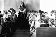 Students from Fort Albany Residential School reading in class overseen by a nun, circa 1945. From the Edmund Metatawabin collection at the University of Algoma. (Wikimedia Commons)