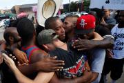 People hug after taking part in a prayer circle July 10 following a Black Lives Matter protest in the wake of multiple police shootings in Dallas (CNS photo/Carlo Allegri, Reuters).
